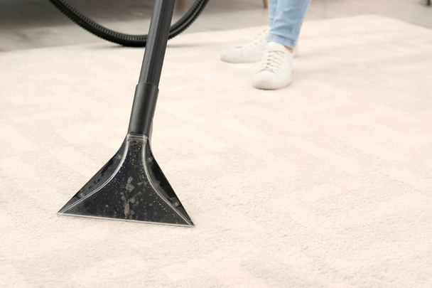 Woman removing dirt from carpet with vacuum cleaner indoors, closeup. Space for text - Φωτογραφία, εικόνα