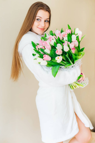 Charming woman with long hair holding big bouquet of pink and white tulips isolated. - Fotoğraf, Görsel
