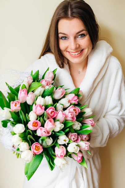 Дівчина з щирою посмішкою тримає гарний букет тюльпанів. природна краса. весняний букет нареченої. щасливий жіночий день
. - Фото, зображення