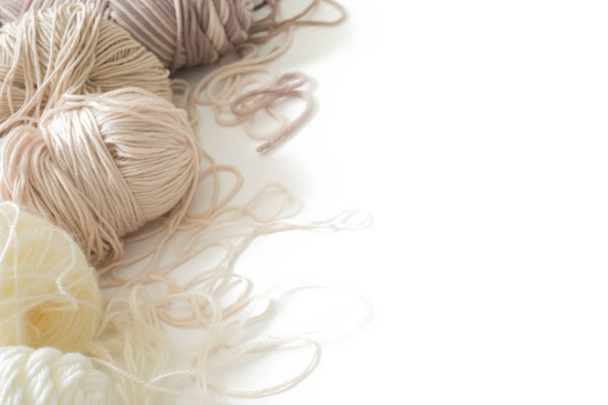 The yarn is beige, brown, gray and white. Knitting needles, scissors, knitting, knitted fabric. - Foto, Imagen