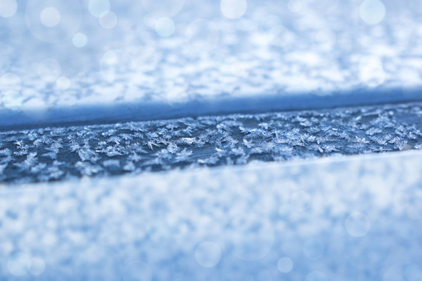Fiocchi di neve sopra l'auto da vicino, all'alba. Sfondo invernale. DOF poco profondo
. - Foto, immagini
