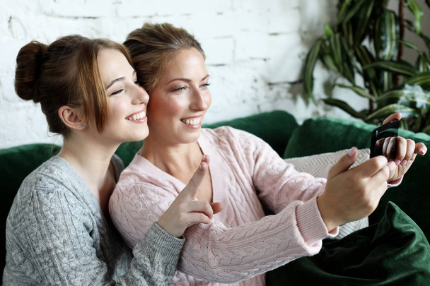  Aged woman and her adult daughter using smartphone at home. - Valokuva, kuva