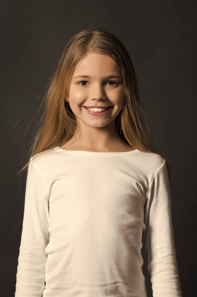 Girl with smile on cute face on dark background - Fotografie, Obrázek
