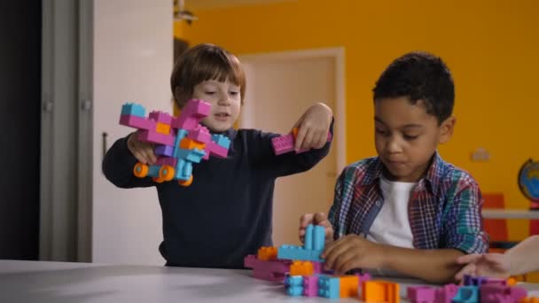 Zwei unterschiedliche Kinder streiten um Spielzeug im Kindergarten - Filmmaterial, Video