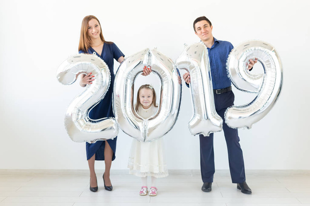 New 2019 Year is coming concept - Family are holding silver colored numbers indoors. - Foto, Bild