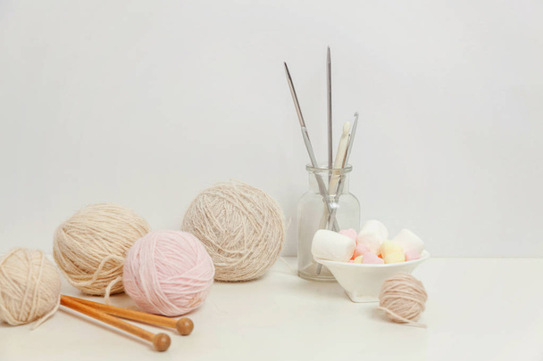 Needlework crocheting and knitting club creative workspace. Needlewoman white table cozy workplace with woolen yarn, knitting needles. Working at home women leisure hobby handmade concept. Copy space - Photo, Image