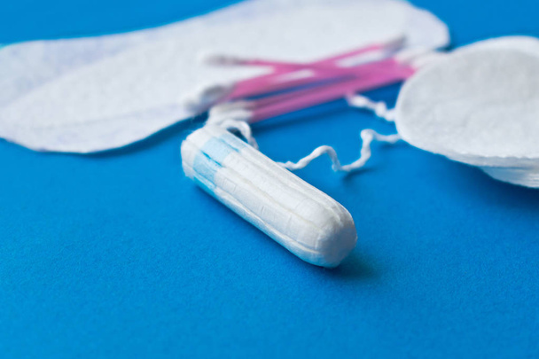 De bescherming van de hygiëne van de vrouw. Katoenen tampons op blauwe achtergrond - Foto, afbeelding