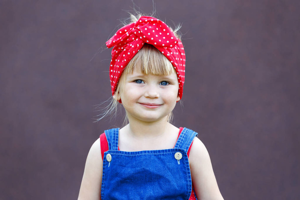 Little girl with polka-dot headband laughs and looks at the viewer. Copy space.  - Foto, immagini