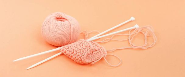 Banner knitting wool and knittig needles on coral color background - 写真・画像