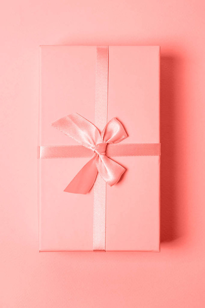Gift box colored in trendy color of year 2019 Living Coral background. Bright Macro color 16-1546. Christmas New Year birthday valentine celebration present romantic concept. Flat lay top view - Photo, Image