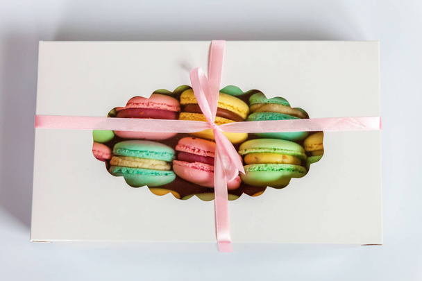 süße Mandel bunte rosa, blau, gelb, grün Macaron oder Makronen Dessertkuchen in Geschenkbox isoliert auf weißem Hintergrund. Französisch süße Kekse. Minimales Bäckereikonzept. flache Lage, Draufsicht, Kopierraum - Foto, Bild