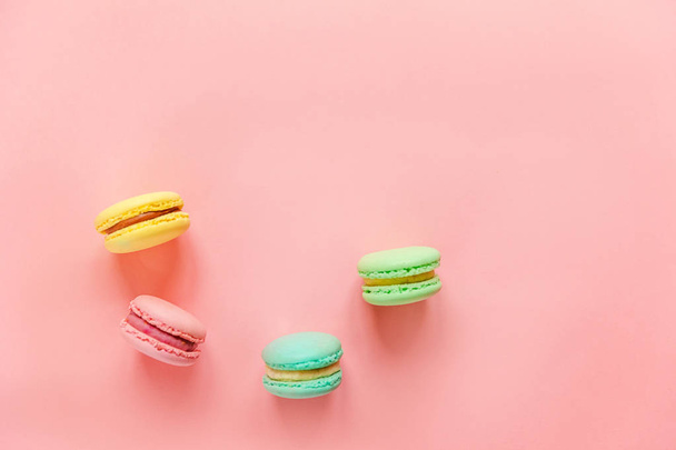 Γλυκό αμύγδαλο πολύχρωμο ροζ μπλε κίτρινο πράσινο macarons ή ζάχαριν επιδόρπιο τούρτα απομονώνονται σε μοντέρνα ροζ παστέλ φόντο.  - Φωτογραφία, εικόνα