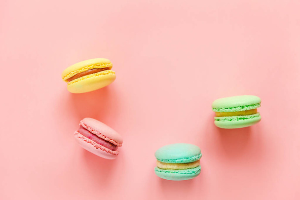 süße Mandeln bunte rosa blau gelb grüne Macarons oder Makronen Desserttorte isoliert auf trendigen rosa Pastell Hintergrund.  - Foto, Bild