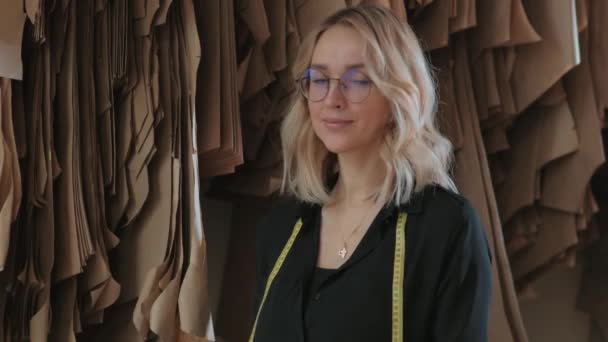 Mladá blond žena v šití studio a studuje šicích vzorů - Záběry, video