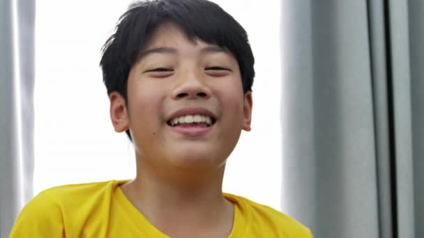 Portret azjatycki dziecko patrząc na kamery z uśmiechem twarz, zwolnionym tempie 4k z cute Tajlandia pre teen chłopiec . - Materiał filmowy, wideo