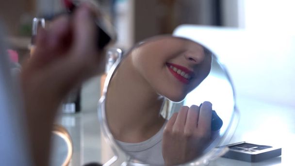 Lady putting seductive evening makeup smiling to her reflection in mirror - Φωτογραφία, εικόνα