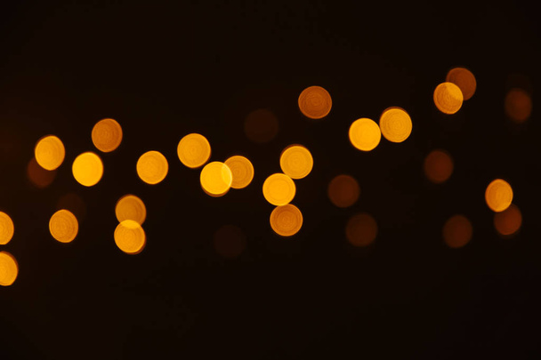 Abstract Gold bokeh sparkle on black background. Lights blurred bokeh  for christmas design - 写真・画像