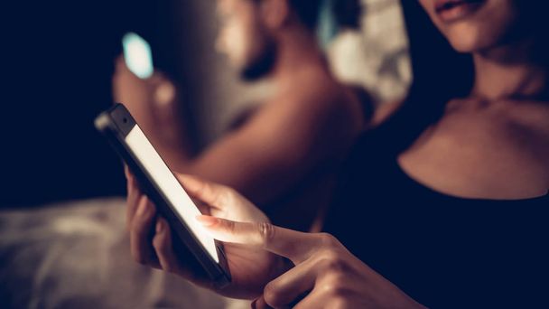 Couple in Love in Bed Using Mobile Phone at Night - Photo, Image