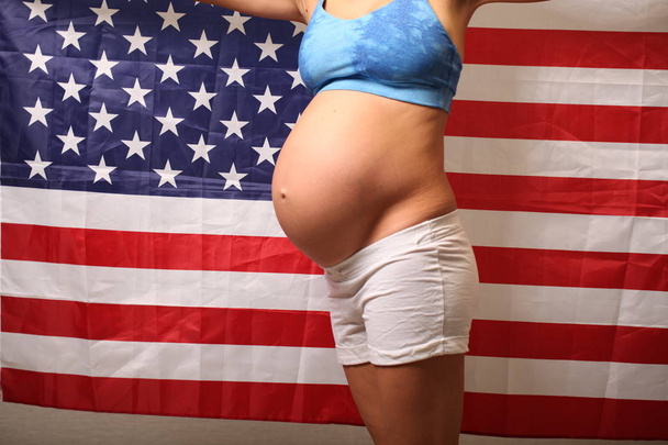 Fertility in america concept pregnant girl and american flag - Fotó, kép