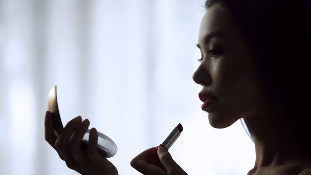Charming girl carefully putting on red lipstick, slowly painting beautiful lips - Zdjęcie, obraz