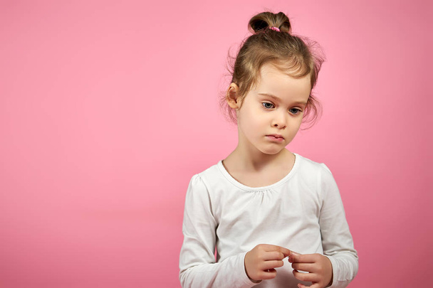 portrait of a cute little girl in tulle skirt on a pink background - Foto, afbeelding