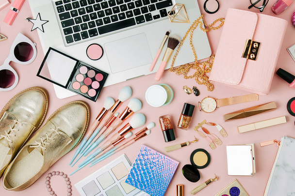 Moda blogger obszaru roboczego z laptopa i kobieta akcesoriów, produktów kosmetycznych na blado różowy stół. Widok płaski świeckich, top - Zdjęcie, obraz