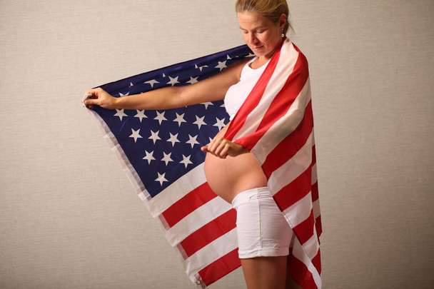 Plodnost v Americe koncept těhotná dívka a americká vlajka - Fotografie, Obrázek