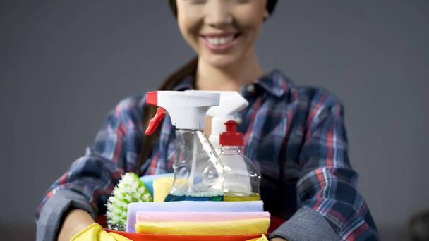 Satisfied hostess loves cleaning products, joyfully smiles into the camera - Foto, Bild