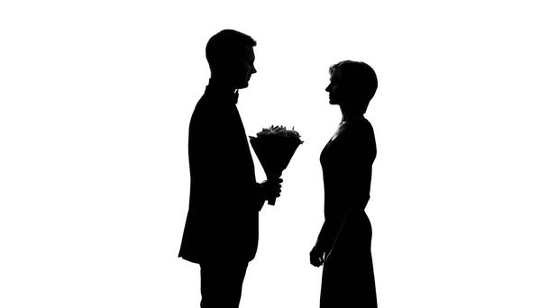 Nuori mies esittelee tyttöystävä kukkakimppu, syntymäpäivä juhla, ensimmäinen päivä
 - Valokuva, kuva