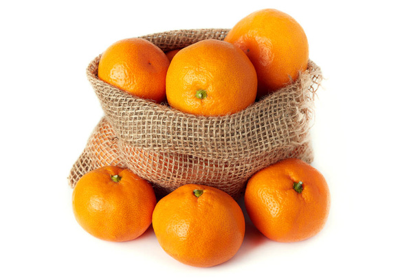 Mandarin orange (Citrus reticulata) also known as the mandarin or mandarine in burlap sack isolated on white background - Photo, Image