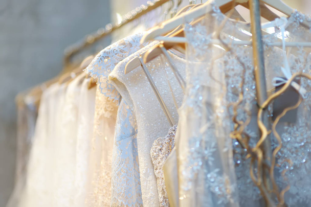 Few beautiful wedding dresses on a hanger. Wedding fashion for beautiful brides. - Photo, image