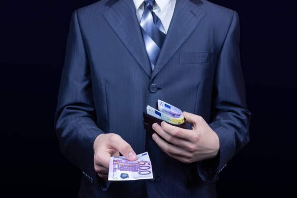 The man in the suit removes the money in the wallet, the businessman wallet Euro - 写真・画像