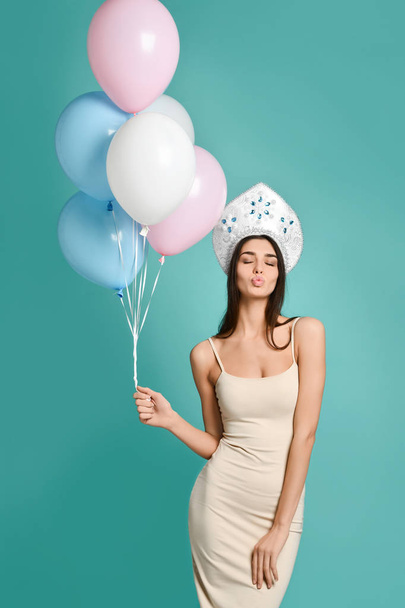 Amazed woman holding balloon and gift box over gray background. Looking at camera. - Zdjęcie, obraz