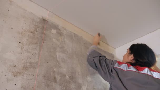 Mujer aplicando pegamento de papel pintado en la pared
 - Metraje, vídeo