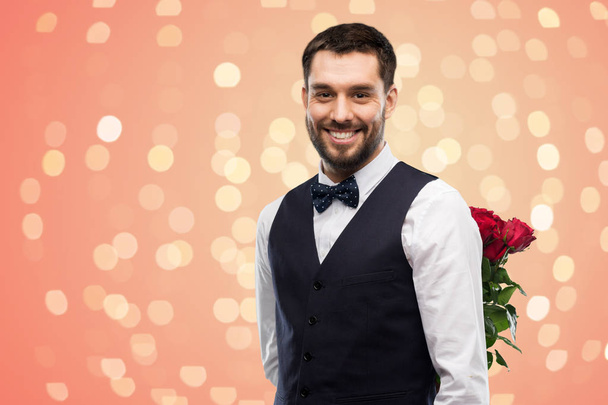 happy man with red roses behind his back - 写真・画像