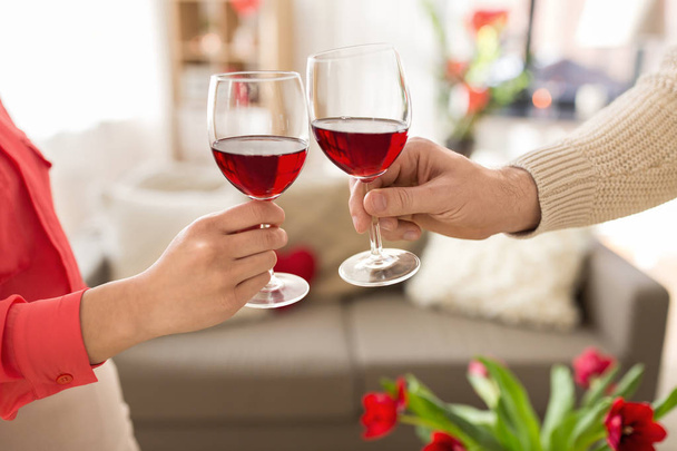 hands of couple with red wine glasses toasting  - Photo, Image