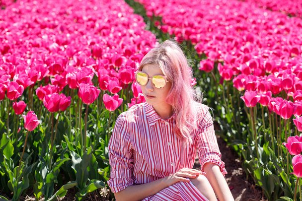 Smiling teenage girl walks through tulip field.Holland - Photo, image