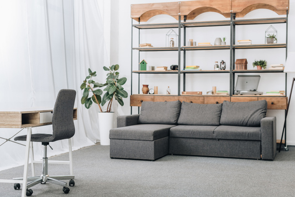 moderna sala de estar con sofá, bastidores y espacio de trabajo
 - Foto, Imagen
