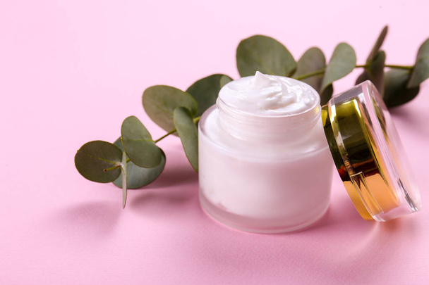 Moisturizing care skincare face cream for healing complicated troubled skin type in an open jar with visible texture. Copy space, close up, background, flat lay, top view. Eucalyptus leaf decoration. - Фото, изображение