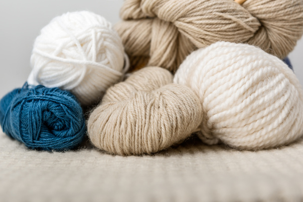 close up view of arranged yarn clews on woolen surface on grey background - 写真・画像
