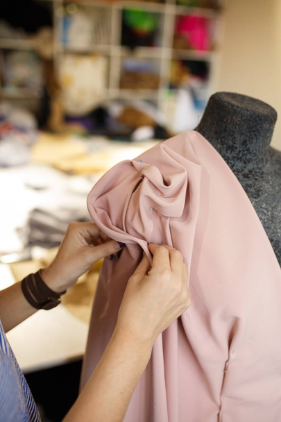 female dressmaker attach fabric to mannequin with needles. creating dress design. Tailor industry concept. - Foto, Imagem