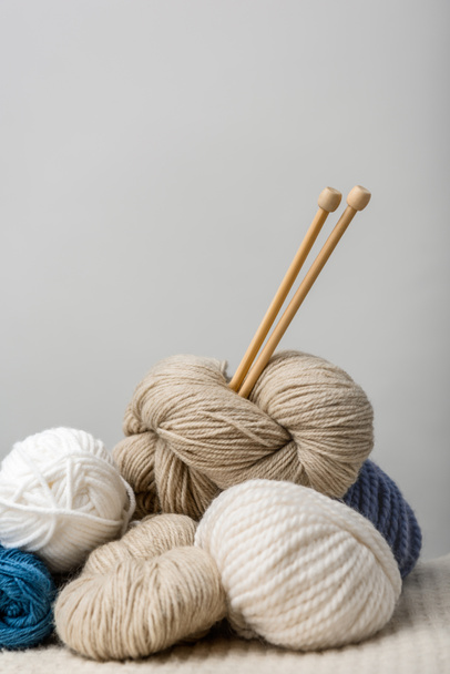 close up view of knitting needles in yarn clews on grey background - Φωτογραφία, εικόνα