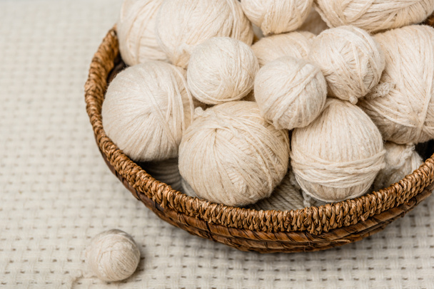 close up view of yarn balls in wicker basket on white backdrop - Photo, Image