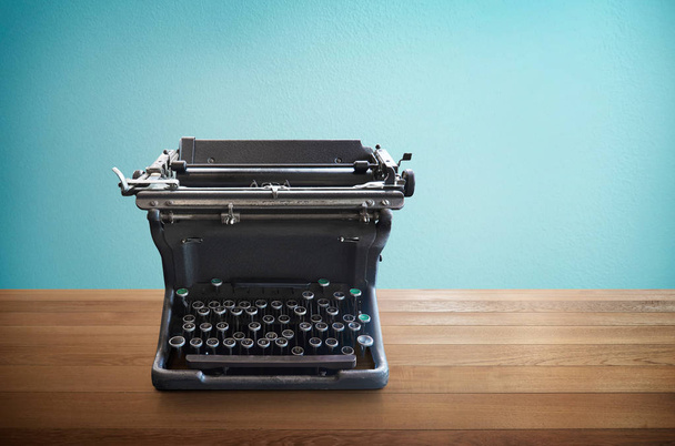 Antiguo vintage retro negro máquina de escribir sobre tabla de madera con fondo azul menta
 - Foto, Imagen