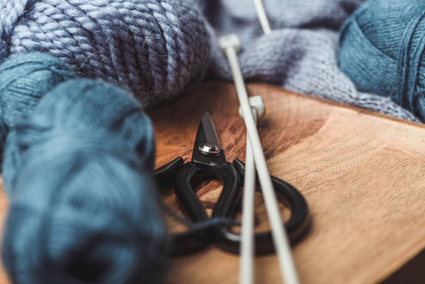 vue rapprochée des pinces à tricoter, aiguilles à tricoter et ciseaux sur plateau en bois
 - Photo, image