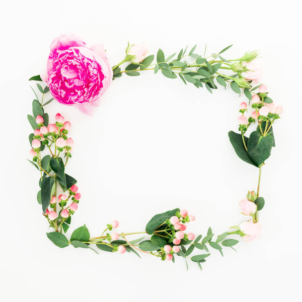 Floral frame of pink peony and roses flowers, hypericum and eucalyptus branches on white background. Flat lay, top view - Фото, зображення