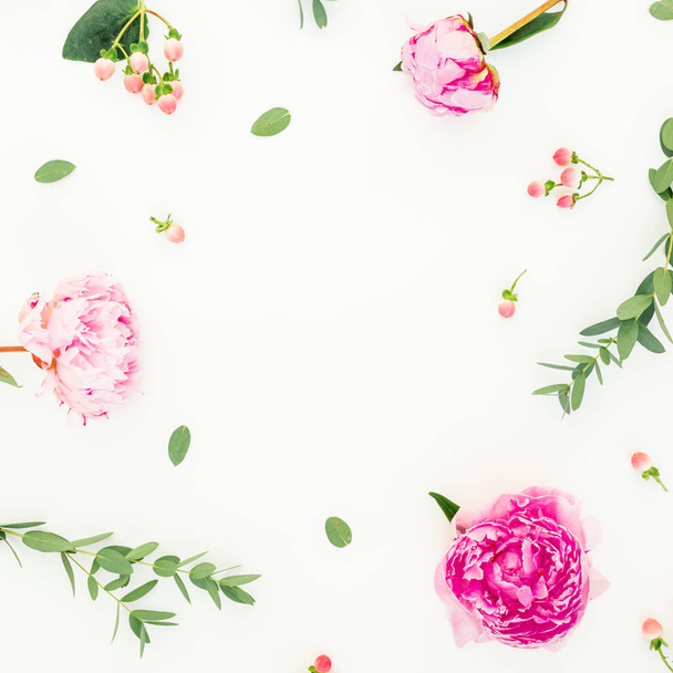 Floral frame of pink peonies, hypericum and eucalyptus leaves on white background. Flat lay, top view - Foto, Bild