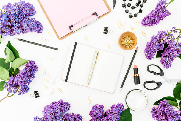 Vrouwelijke samenstelling met Klembord, dagboek, lippenstift, lila bloemen en accessoires op witte achtergrond. Plat lag, top uitzicht. - Foto, afbeelding