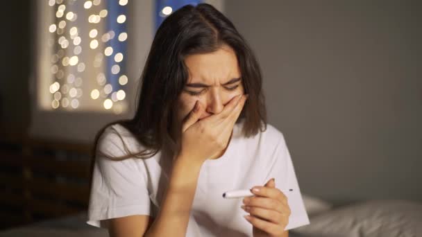 sad woman looking on pregnancy test unexpected cries - Video, Çekim