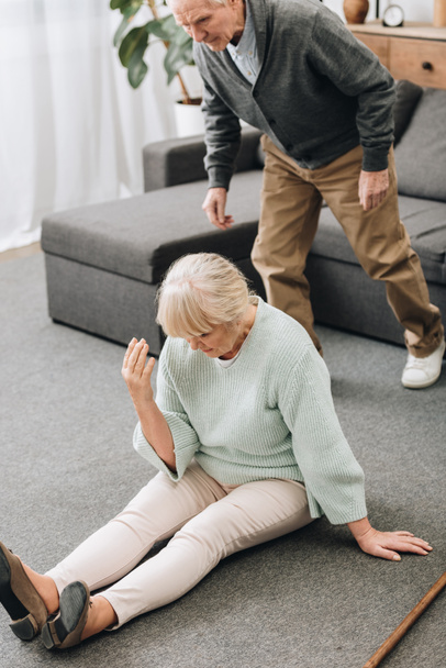 retired husband coming to upset wife sitting on floor  - Foto, Bild